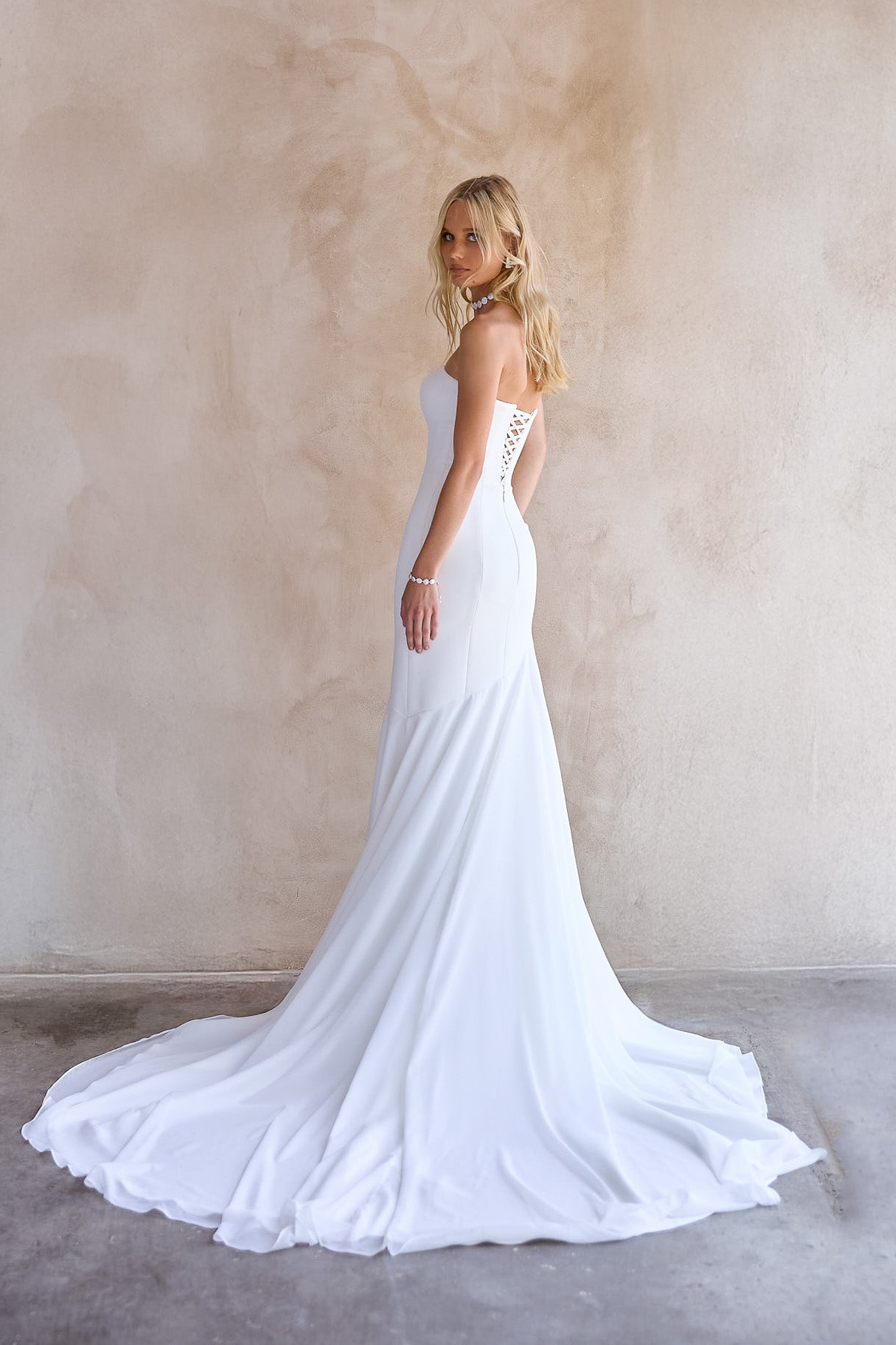 back Image of the June Wedding dress by The Bryde, with no detachable bow. made from crepe main fabric and a soft chiffon angled skirt