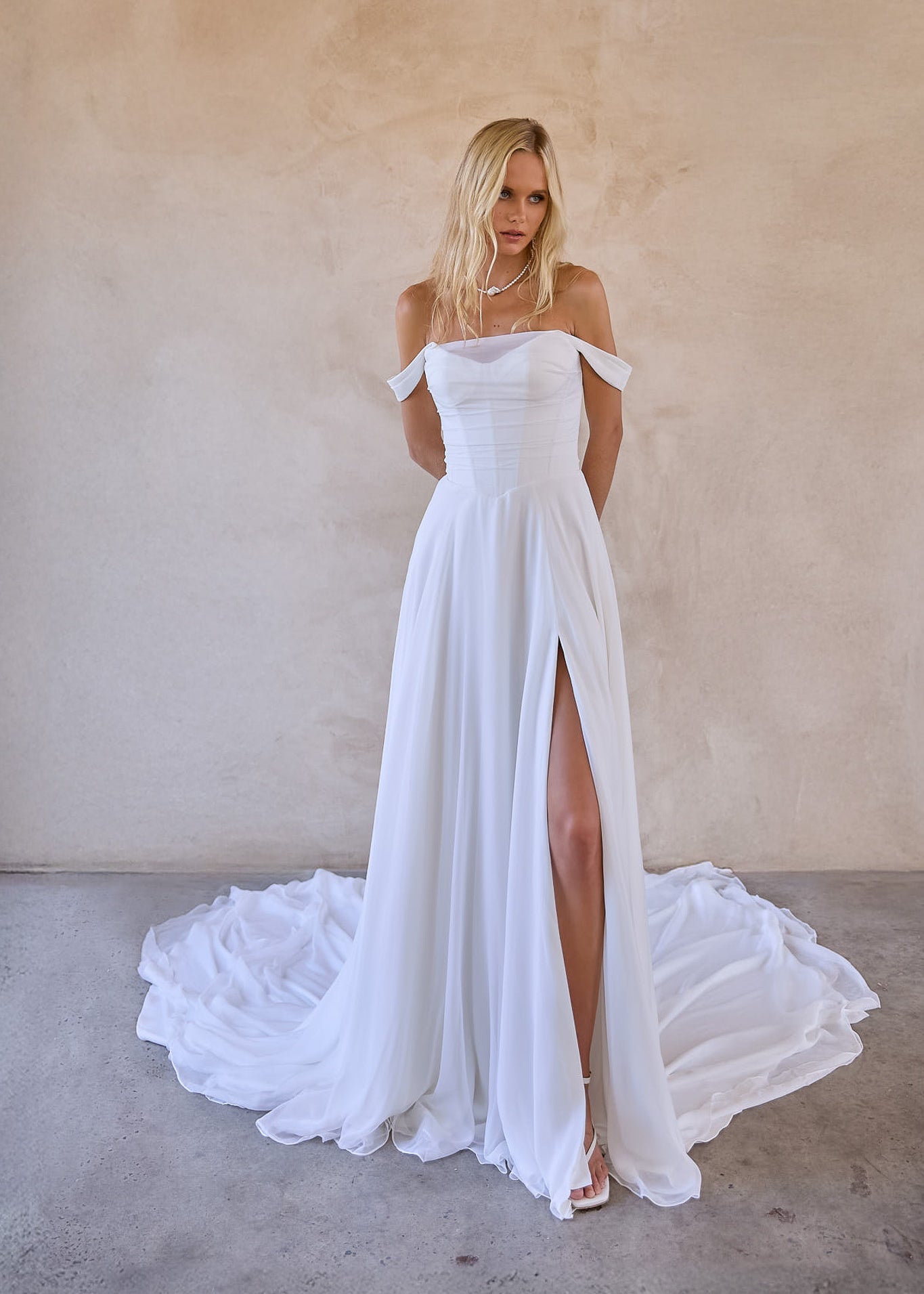 designed in australia available to buy online worldwide - jessi is an off shoulder chiffon a-line wedding dress with thigh high split. ruched chiffon bodice with v waist design to enhance silhouette