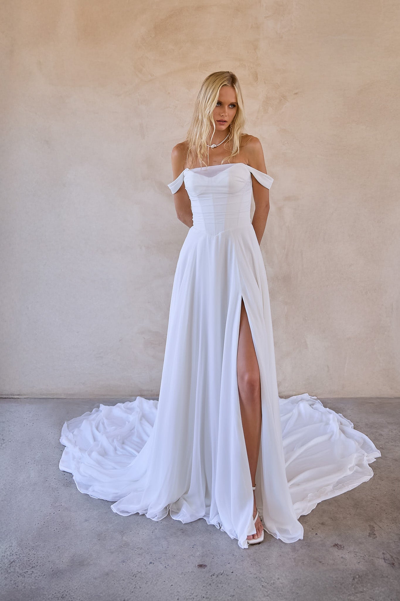 designed in australia available to buy online worldwide - jessi is an off shoulder chiffon a-line wedding dress with thigh high split. ruched chiffon bodice with v waist design to enhance silhouette